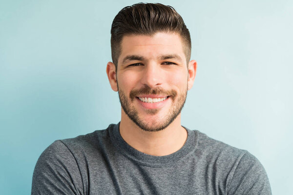 Portrait of attractive Hispanic male smiling in studio