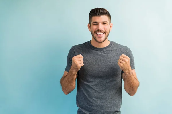 Retrato Joven Feliz Pie Mientras Muestra Los Puños Contra Fondo —  Fotos de Stock