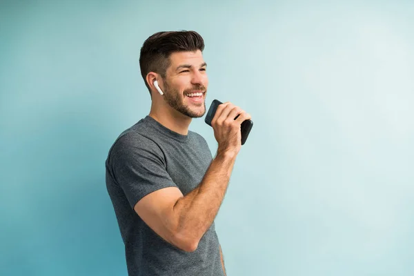 Attraktiver Smarter Mann Singt Während Sein Smartphone Vor Türkisfarbenen Hintergrund — Stockfoto