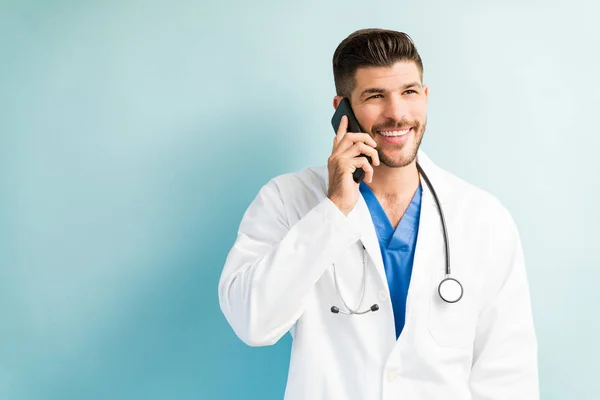 Sonriente Joven Cirujano Atractivo Hablando Teléfono Móvil Con Fondo Llano — Foto de Stock