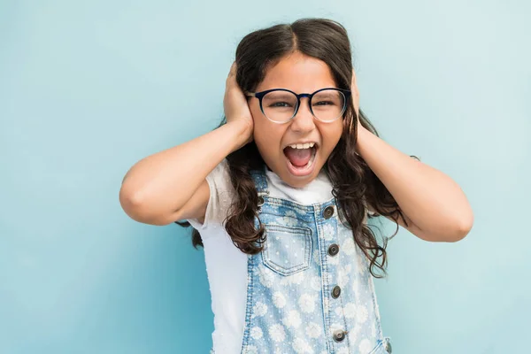 Retrato Niña Molesta Cubriendo Orejas Mientras Grita Sobre Fondo Liso —  Fotos de Stock