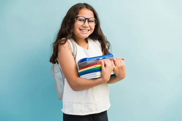 笑顔かわいいです女の子立って本とともにアイコンタクトを作りながら隔離されましたターコイズの背景 — ストック写真