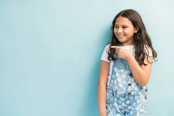 Sorrindo Bonito Latina Menina Apontando Enquanto Olha Para Longe Estúdio — Fotografia de Stock