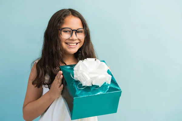 Glückliches Weibliches Kind Hält Geschenkschachtel Mit Schleife Während Blickkontakt Vor — Stockfoto