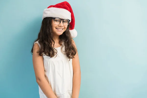 Entzückendes Lateinisches Mädchen Mit Weihnachtsmütze Stehen Und Blickkontakt Vor Türkisfarbenem — Stockfoto