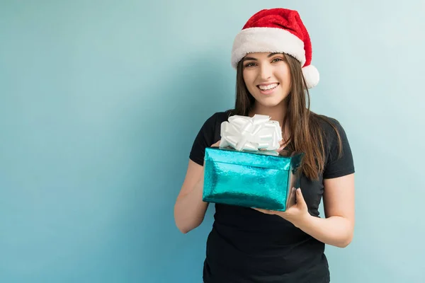 Hermosa Mujer Joven Sosteniendo Regalo Navidad Mientras Hace Contacto Visual —  Fotos de Stock
