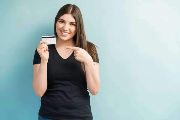 Приваблива Жінка Посміхається Вказуючи Кредитну Картку Звичайному Тлі — стокове фото