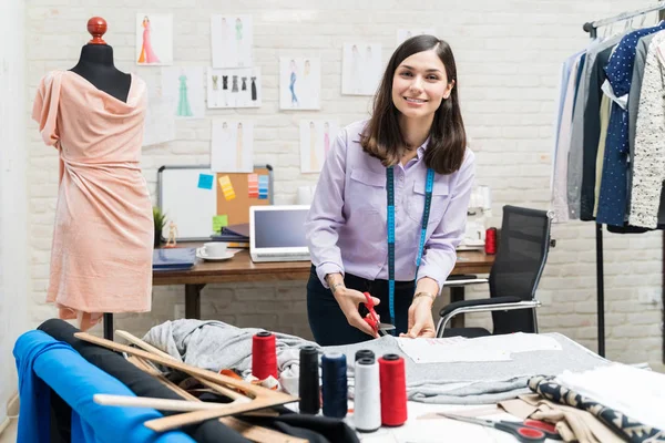 Lächelnde Junge Lateinamerikanische Modedesignerin Schneidet Textilien Während Sie Blickkontakt Modestudio — Stockfoto