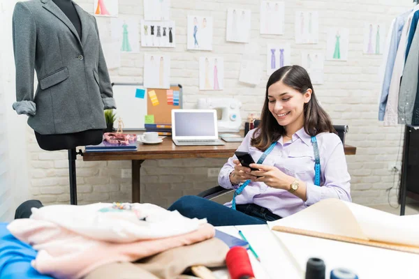 Sorrindo Designer Feminino Mensagens Texto Telefone Celular Enquanto Sentado Mesa — Fotografia de Stock