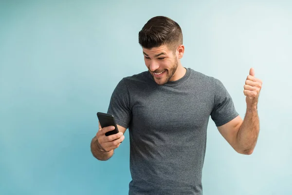 Emocionado Hombre Hispano Leyendo Buenas Noticias Teléfono Inteligente Contra Fondo — Foto de Stock