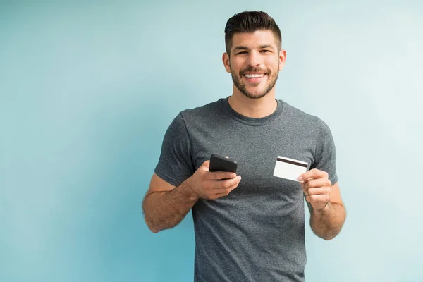 Ευτυχισμένο Έξυπνο Νεαρό Άνδρα Χιλιετή Κρατώντας Πιστωτική Κάρτα Και Κινητό — Φωτογραφία Αρχείου