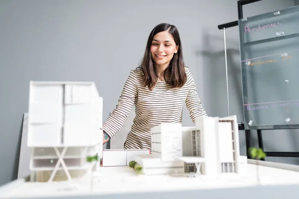 Atrakcyjny Uśmiechnięty Inżynier Patrzący Model Architektoniczny Miejscu Pracy — Zdjęcie stockowe