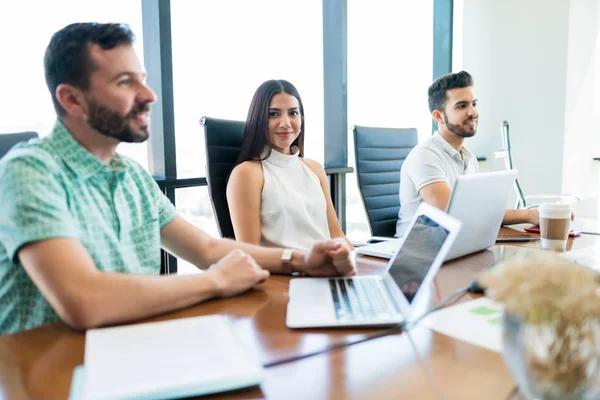 Hermosa Joven Empresaria Haciendo Contacto Visual Mientras Sienta Medio Colegas — Foto de Stock