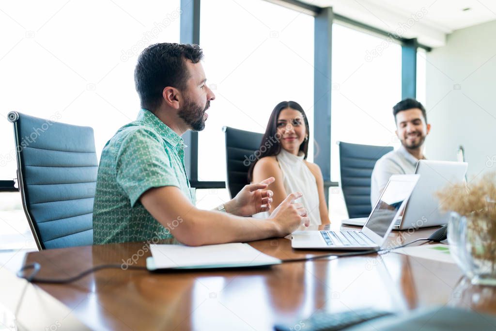 Confident manager explaining plan to colleagues during meeting in room at office