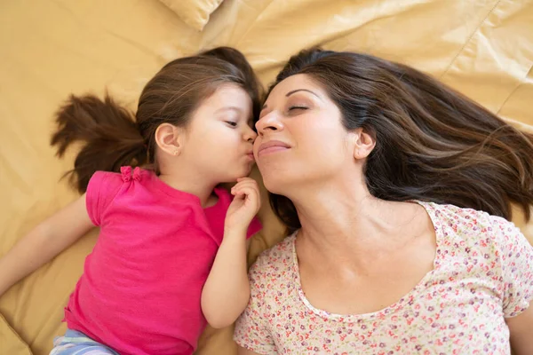 Top View Pretty Little Girl Kissing Her Mother Cheek While — Stock Photo, Image