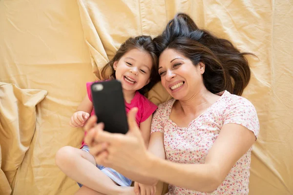 Widok Góry Cute Little Girl Jej Matka Biorąc Selfie Podczas — Zdjęcie stockowe