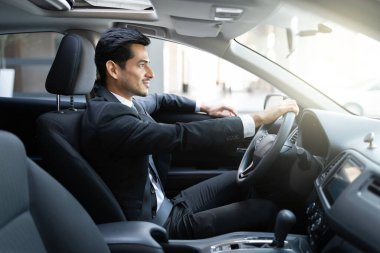 Kentteki genç İspanyol işletme yöneticisi sürücü arabasının yan görüntüsü