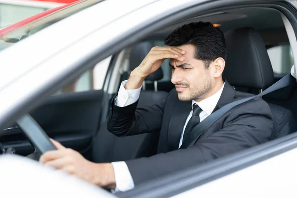 Młody Biznesmen Cierpiący Ból Głowy Podczas Jazdy Samochodem Mieście — Zdjęcie stockowe
