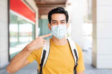 Kentteki koronavirüs krizi sırasında yüz maskesi takan İspanyol genç adam.