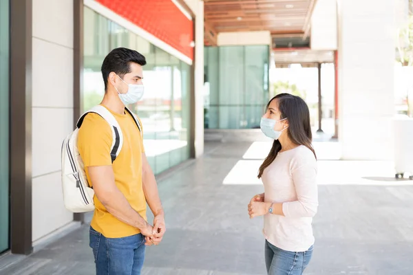 コロナウイルス発生時にお互いに話し合いながら社会的距離を保つ男女 — ストック写真