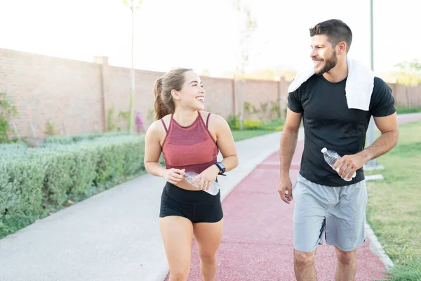 Smiling Athletic Man Woman Water Bottles Talking While Walking Park — Stock Photo, Image