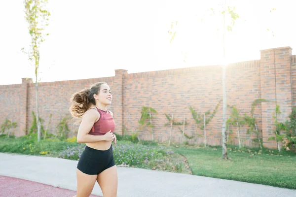 Kamu parkında koşan kendinden emin, beyaz bir kadın.