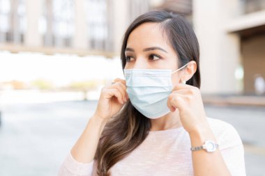 Kafkasyalı kadın COVID19 salgını sırasında maske takıp başka tarafa bakıyordu.