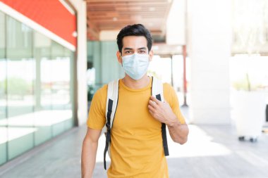 Coronavirus krizi sırasında şehirde yüz maskesi takan İspanyol genç adam.