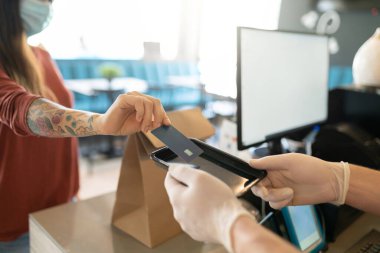 Müşteri kredi kartını Coronavirus salgını sırasında restoranda çalışanların elinde tutuyor.