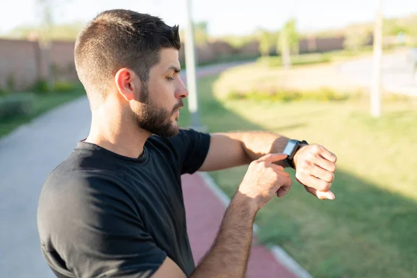 Atletisk Latinsk Ung Man Kollar Tid Smartwatch Medan Tränar Parken — Stockfoto