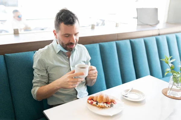 コロナウイルス危機の間 カフェでコーヒーと甘い食べ物を持っている白人中世の成人男性 — ストック写真