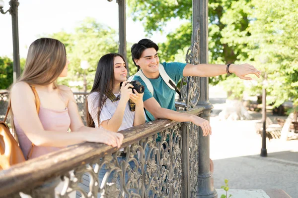 Mujer Joven Sonriente Con Cámara Mirando Hombre Señalando Durante Viaje —  Fotos de Stock