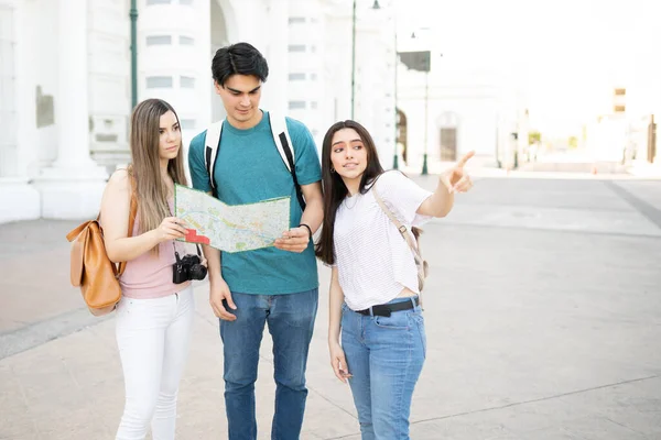 Mujer Joven Señalando Guiando Amigos Sosteniendo Mapa Durante Viaje Ciudad —  Fotos de Stock