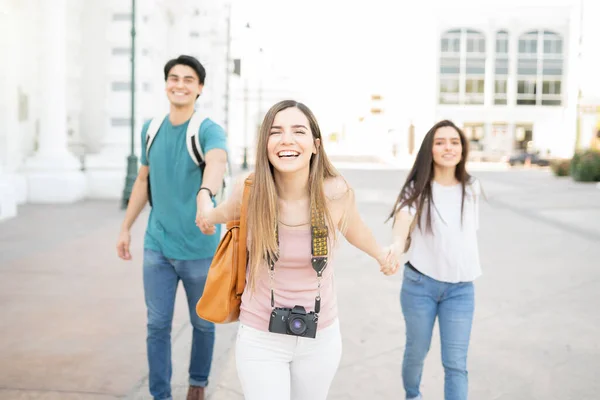 Feliz Joven Mujer Cogida Mano Amigos Mientras Camina Ciudad Durante —  Fotos de Stock