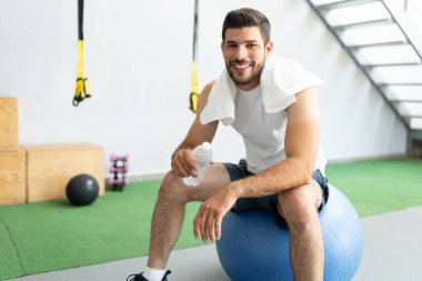 fitness stüdyosunda spor yaptıktan sonra ara veren kendinden emin Latin bir gencin portresi.