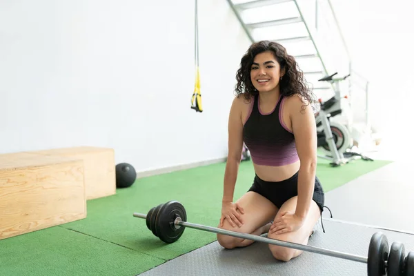 Lachende Spaanse Jonge Vrouw Knielend Rustend Een Fitnessclub — Stockfoto