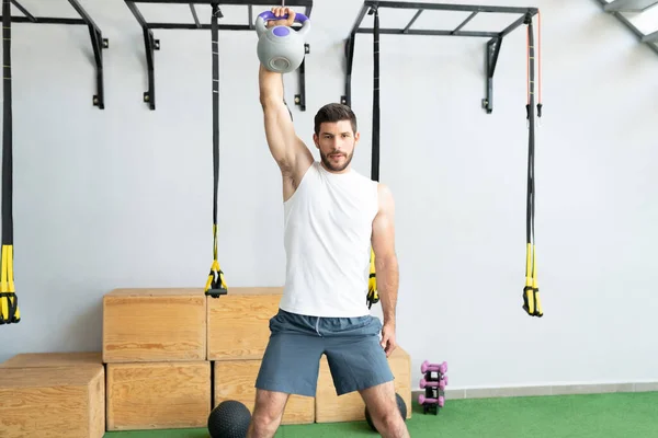 Selbstbewusster Gut Aussehender Junger Mann Trainiert Mit Der Kettlebell Crosslaufhalle — Stockfoto