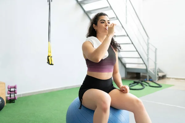 Uitgeput Jonge Vrouw Drinken Van Water Tijdens Het Zitten Fitness — Stockfoto