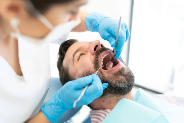 Odontóloga Examinando Paciente Con Espejo Tallador Clínica — Foto de Stock