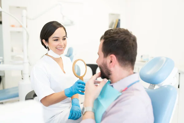 Ortodoncista Femenina Sonriente Mostrando Espejo Hombre Después Del Tratamiento Ortodoncia — Foto de Stock