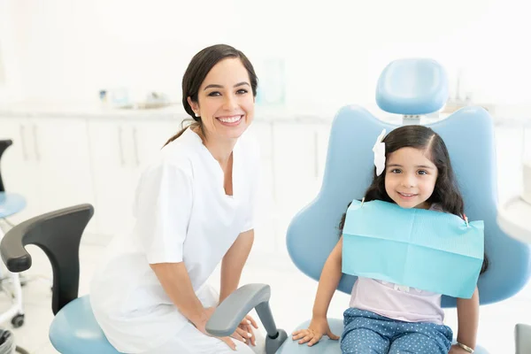 Pewna Siebie Biała Dentystka Uroczą Dziewczynką Siedzącą Krześle — Zdjęcie stockowe