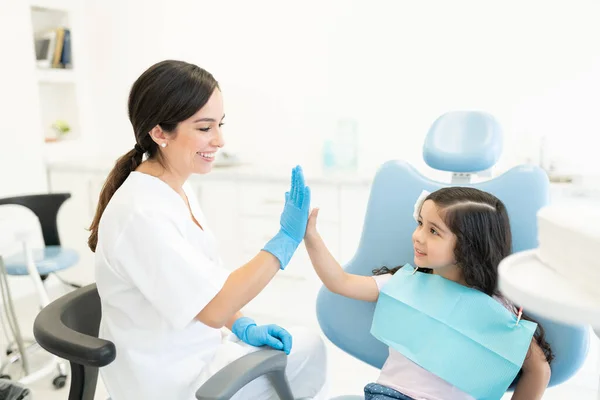 Cute Latynoska Dziewczyna Przybija Piątkę Dentystką Podczas Kontroli Klinice Stomatologicznej — Zdjęcie stockowe