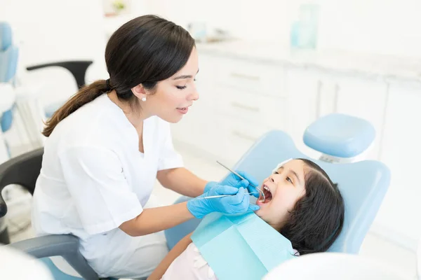 Dentista Femminile Esaminando Carina Bambina Con Specchio Dentale Intagliatore — Foto Stock