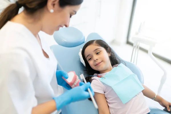 Dentista Feminina Ensinando Uma Garotinha Escovar Corretamente Dentes Usando Modelo — Fotografia de Stock