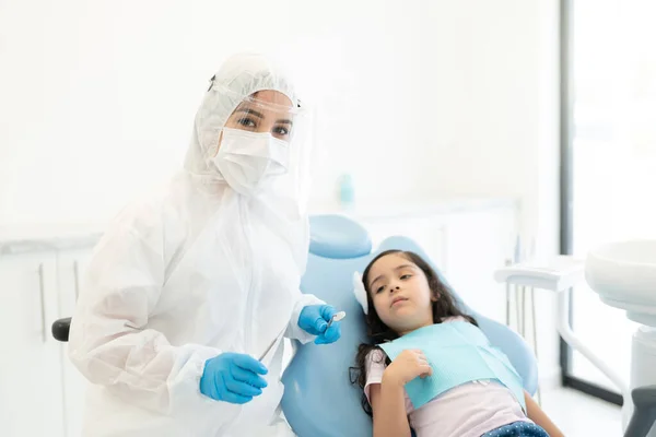 Dentista Roupa Trabalho Protetora Examinando Menina Durante Surto Coronavírus — Fotografia de Stock