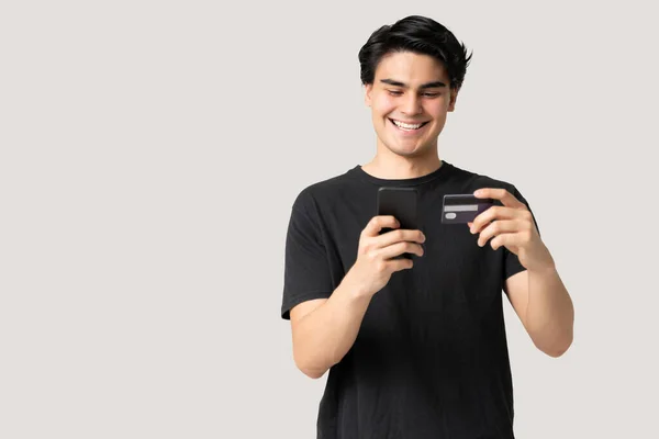 Χαμογελώντας Όμορφος Νεαρός Άνδρας Ψώνια Μέσω Πιστωτικής Κάρτας Στο Κινητό — Φωτογραφία Αρχείου