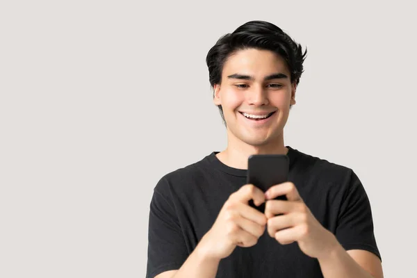 Knappe Spaanse Man Glimlachen Tijdens Het Sms Smartphone Tegen Grijze — Stockfoto