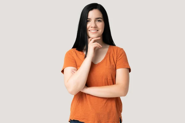 Turuncu Tişörtlü Gülümseyen Genç Kadın Elleri Çenesinde Duruyor — Stok fotoğraf