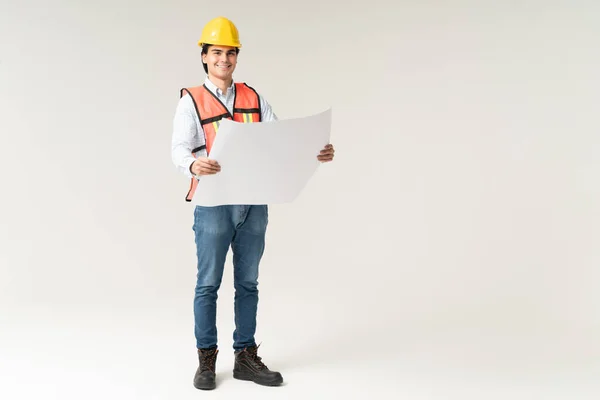 Confident Latin Young Male Contractor Blueprint Isolated Gray Background — Stock Photo, Image