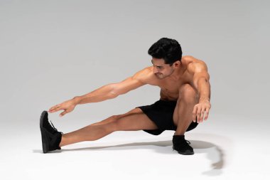 Spor yaparken parmaklarına dokunan kaslı genç adam.